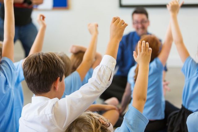 1_Excited-School-Children-in-Uniform-with-Hands-Up