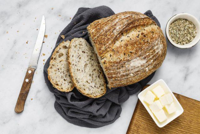 Fresh homemade sourdough bread with butter on a napkin, top view