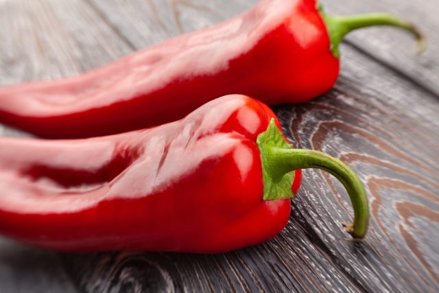 Long,Pepper,On,Wood,Background